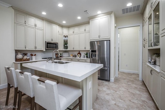 kitchen with a sink, stainless steel appliances, visible vents, and light countertops