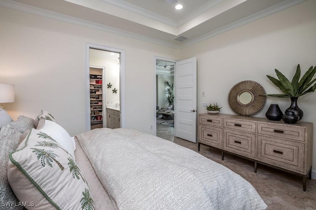 bedroom featuring a tray ceiling, ensuite bathroom, visible vents, and crown molding