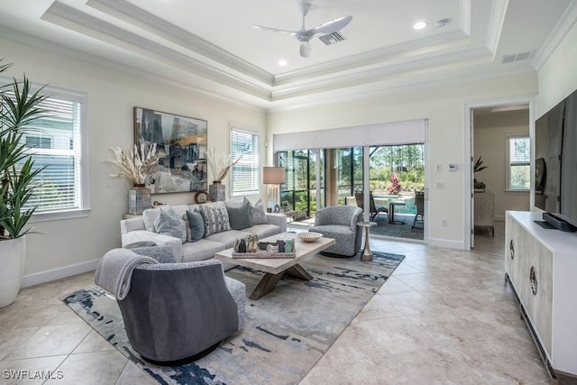 living area with a wealth of natural light, visible vents, and a raised ceiling