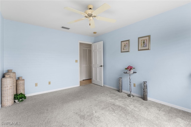 interior space featuring visible vents, a ceiling fan, baseboards, and carpet floors