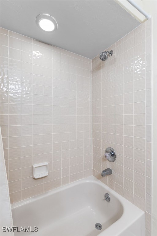 bathroom with shower / bath combo with shower curtain