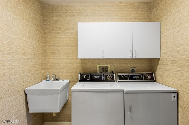 laundry room with washer and clothes dryer, cabinet space, and a sink