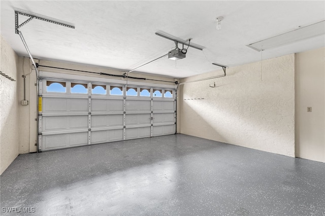 garage with a garage door opener and a textured wall