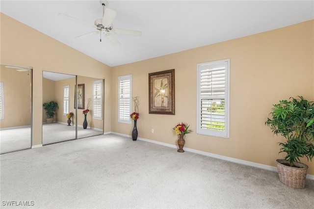 unfurnished bedroom featuring multiple closets, baseboards, carpet, vaulted ceiling, and a ceiling fan