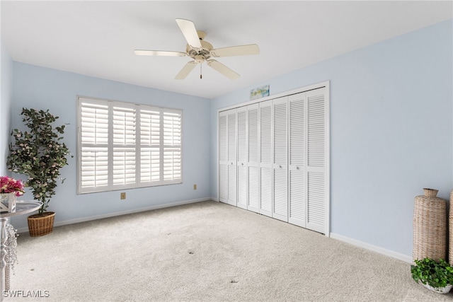 unfurnished bedroom featuring a closet, baseboards, carpet, and a ceiling fan