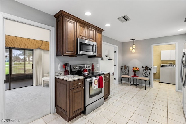 kitchen with visible vents, recessed lighting, appliances with stainless steel finishes, light tile patterned flooring, and washer / dryer