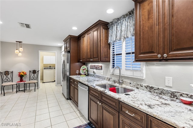 kitchen featuring light tile patterned floors, visible vents, washer / dryer, stainless steel appliances, and a sink