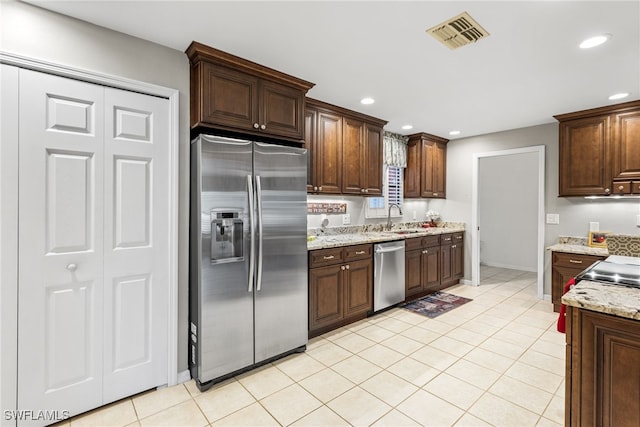 kitchen with visible vents, a sink, recessed lighting, stainless steel appliances, and light stone countertops