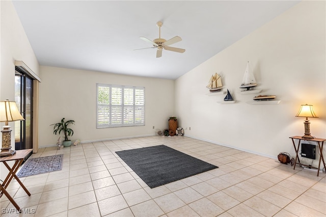 interior space with lofted ceiling, light tile patterned floors, a ceiling fan, and baseboards