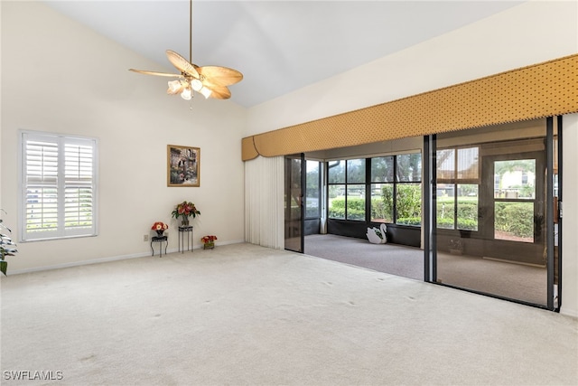 spare room featuring baseboards, high vaulted ceiling, ceiling fan, and carpet floors