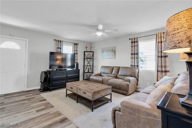 living room with light wood-style flooring, baseboards, a healthy amount of sunlight, and ceiling fan