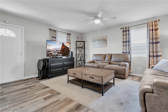 living area featuring a wealth of natural light, light wood-style flooring, and baseboards