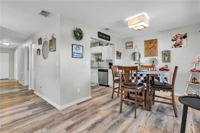 dining area with visible vents, baseboards, and light wood-style floors