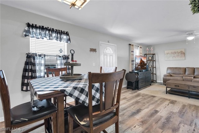 dining area featuring light wood finished floors and baseboards