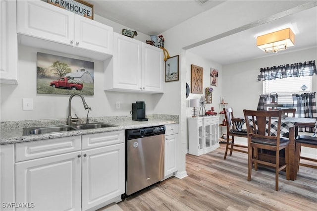 kitchen with a sink, light wood-type flooring, stainless steel dishwasher, and white cabinets