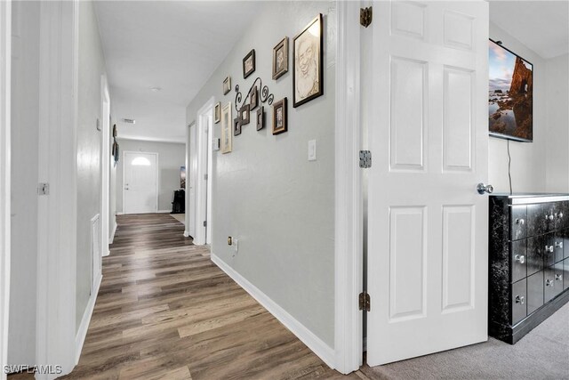 hall featuring baseboards and wood finished floors