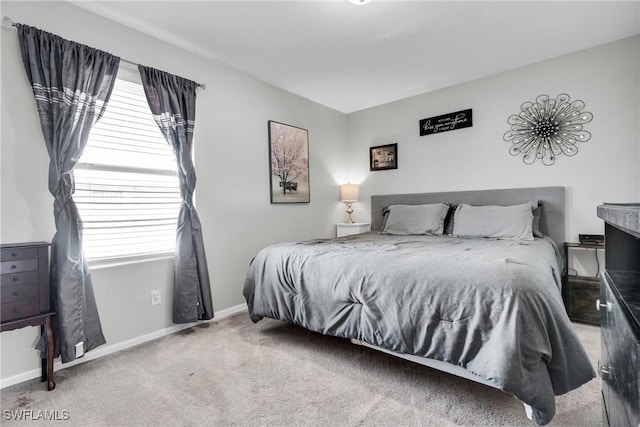 carpeted bedroom featuring multiple windows and baseboards