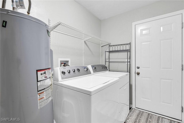 washroom with laundry area, separate washer and dryer, and electric water heater