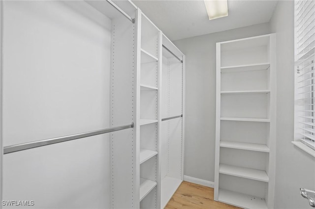 walk in closet with wood finished floors