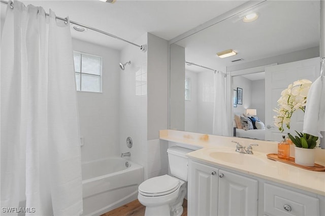 bathroom featuring toilet, wood finished floors, vanity, and shower / bath combination with curtain