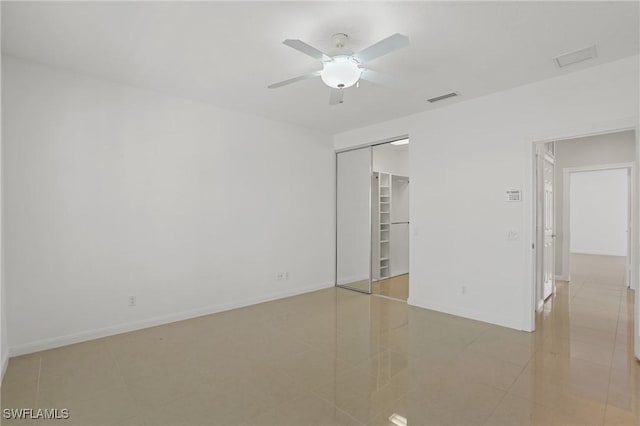 spare room featuring light tile patterned floors, visible vents, baseboards, and ceiling fan