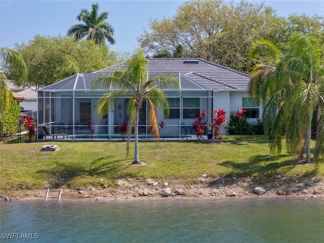 back of house with glass enclosure, a tiled roof, a lawn, and a water view