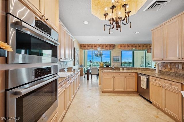 kitchen with visible vents, a chandelier, light brown cabinetry, a peninsula, and stainless steel appliances