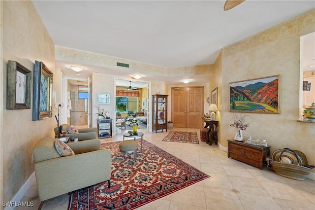 living area with tile patterned flooring, visible vents, and baseboards