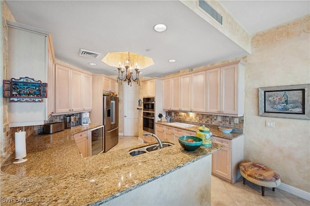 kitchen featuring visible vents, a sink, light stone counters, backsplash, and stainless steel appliances