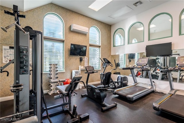 gym featuring a wall unit AC, baseboards, visible vents, and high vaulted ceiling