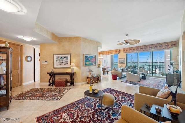 living area with tile patterned floors, baseboards, and a ceiling fan