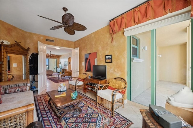 living area with light tile patterned floors, visible vents, and ceiling fan