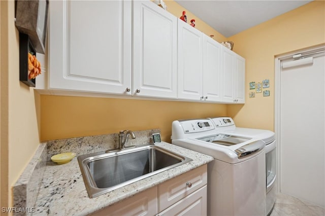 washroom featuring a sink, cabinet space, independent washer and dryer, and light tile patterned flooring