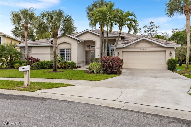 12922 Kedleston Cir, Fort Myers, FL 33912 - view of front of house with french doors, stucco siding, an attached garage, concrete driveway, and a tiled roof