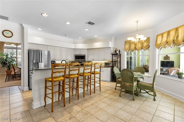 12922 Kedleston Cir, Fort Myers, FL 33912 - kitchen with stainless steel appliances, a chandelier, crown molding, a center island, and light tile patterned floors