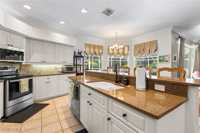 12922 Kedleston Cir, Fort Myers, FL 33912 - kitchen with stainless steel appliances, a sink, plenty of natural light, ornamental molding, and tasteful backsplash