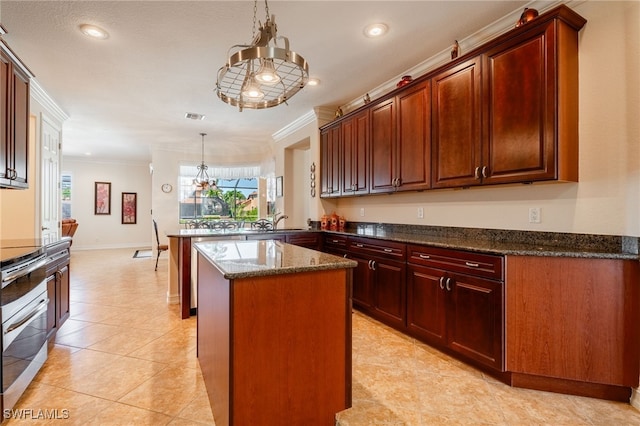 kitchen with visible vents, a center island, crown molding, dark stone countertops, and a peninsula