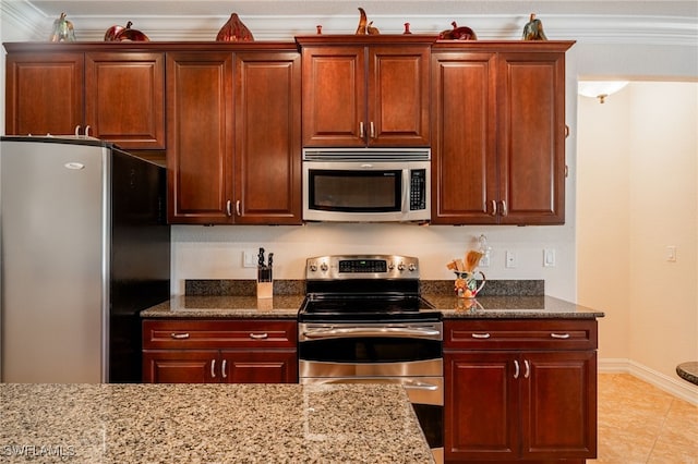 kitchen with dark stone countertops, stainless steel appliances, baseboards, and ornamental molding