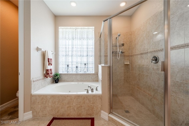 full bathroom featuring tile patterned floors, a garden tub, a stall shower, and toilet