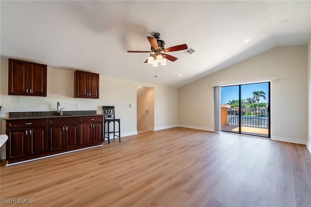 living room featuring visible vents, baseboards, light wood-type flooring, lofted ceiling, and a ceiling fan