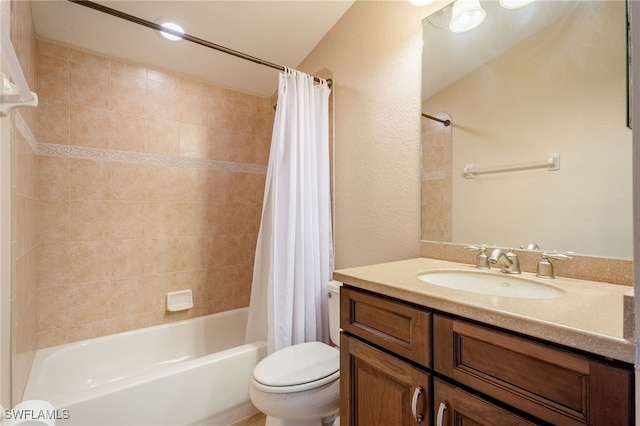 bathroom with vanity, toilet, shower / tub combo, and a textured wall