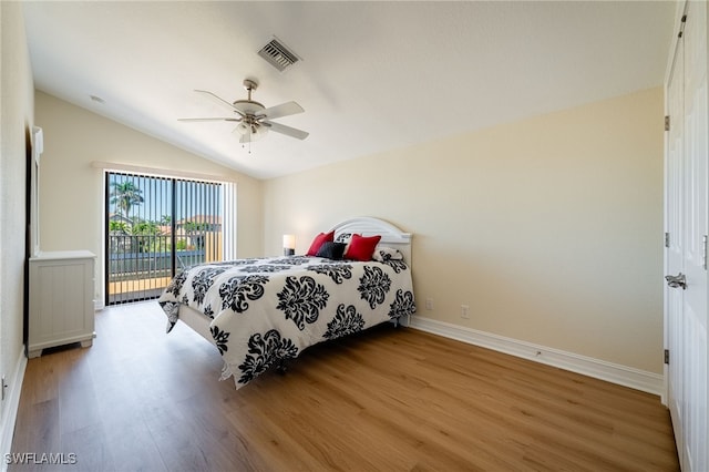 bedroom with visible vents, baseboards, light wood-style flooring, vaulted ceiling, and access to outside