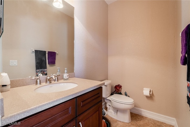 bathroom featuring tile patterned floors, toilet, vanity, and baseboards