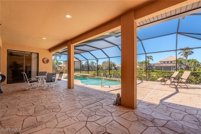 view of pool with a lanai, a pool with connected hot tub, and a patio