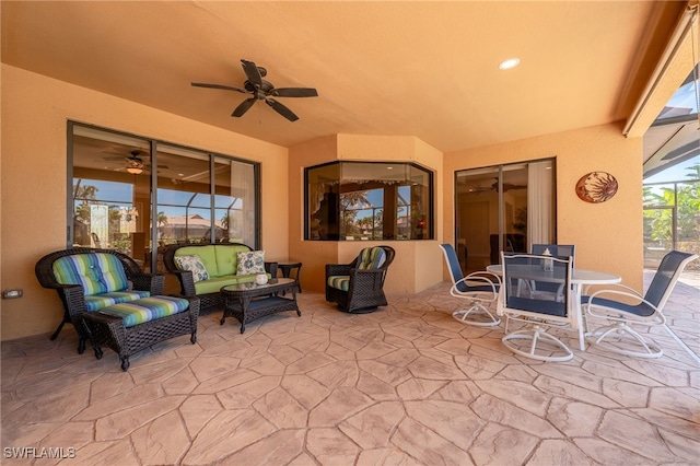 view of patio featuring outdoor lounge area, outdoor dining area, glass enclosure, and ceiling fan