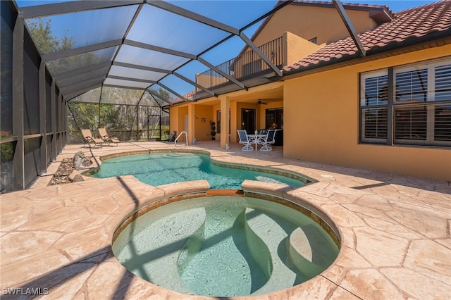 view of swimming pool featuring a patio area, a pool with connected hot tub, and a ceiling fan