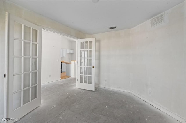 unfurnished room featuring french doors and visible vents