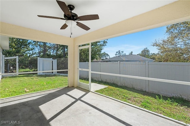 unfurnished sunroom featuring a ceiling fan