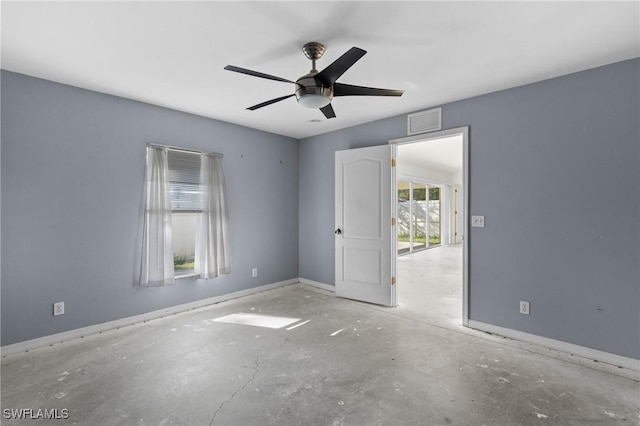 unfurnished room with visible vents, baseboards, concrete flooring, and a ceiling fan