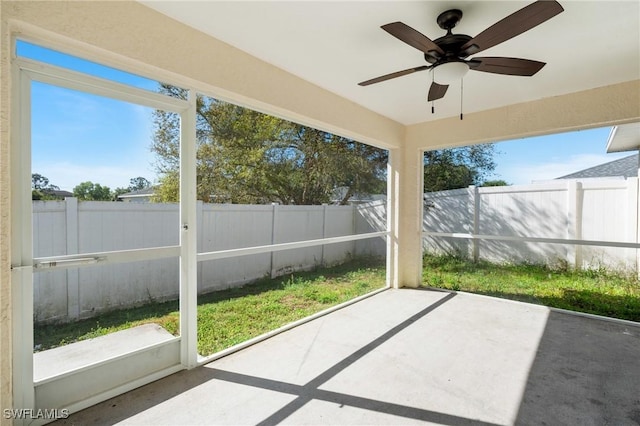 unfurnished sunroom featuring a ceiling fan and a healthy amount of sunlight